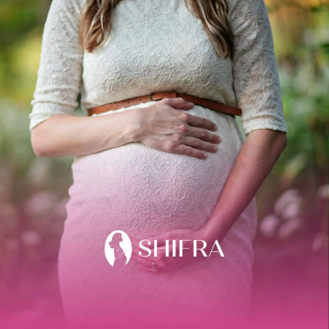 A jewish pregnant woman in crisis wearing a white lace dress holding her huge belly outdoors.