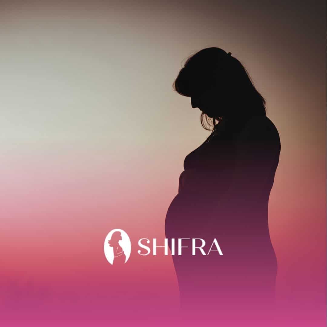 Silhouette of a pregnant woman against a sunset sky, conveying serenity and anticipation.